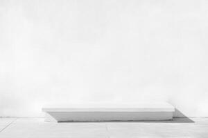 Minimalist white platform in front of textured white wall on a tiled floor, bathed in sunlight photo