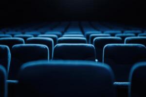 Rows of plush seating, bathed in a cool blue tone, await a captivated audience in the darkness photo