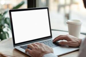 Working on laptop with blank screen, coffee beside, showcasing modern digital workspace photo