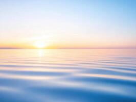 Tranquil ocean sunset reflecting the light of dawn with soft, rippling waves in pale blues photo