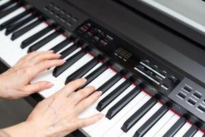 keyboard and hands playing the piano photo