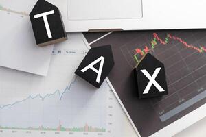 Tax text in wooden cubes and tax or vat form documents to complete Individual income tax return form for payment to Government. Calculation tax return in 2022 to 2023. photo