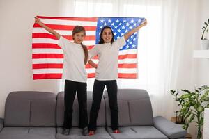 Two sisters with American flag on grey background photo