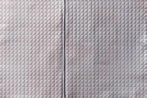 Closeup full-frame background and texture of aluminum coated butil rubber sheet with square pattern. photo