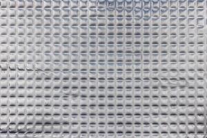 Closeup full-frame background and texture of aluminum coated butil rubber sheet with square pattern. photo