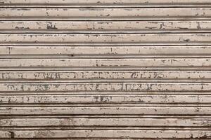 Closeup of a weathered metal shutter with horizontal folding lines photo