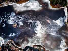 aero drone view of a flooded river during winter, showcasing the powerful and destructive forces of nature photo