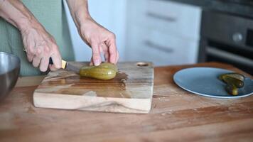 Woman slicing Salted pickles with knife from jar can, Cucumbers preservations, conservation. Salted pickled cucumbers in a wooden table. Preparing the salad video