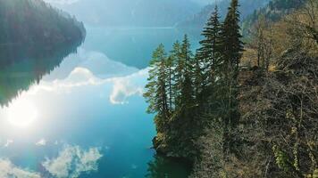 Clear blue mountain lake with reflection of clouds on the water. Drone view video