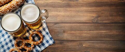 Two glasses of beer with pretzels on a checkered cloth. photo