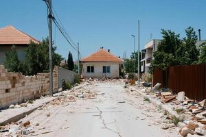 A damaged street with debris and a collapsed building after disaster. photo