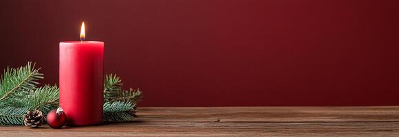 A festive red candle surrounded by pine branches and ornaments. photo
