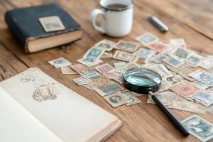 A workspace with stamps, a magnifying glass, and a notebook. photo