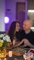 Anniversary Couple enjoying romantic evening with flowers, gift, cookies and candlelight, creating a warm and intimate atmosphere video