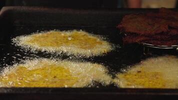 Golden Bramboraky Frying in Oil with Crispy Texture on an Outdoor Griddle video