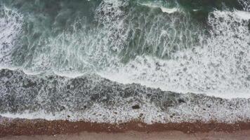 A view of the ocean and waves crashing against the rocky shore with white foam video