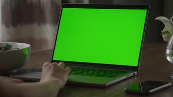 Close up of a caucasian woman hand rest on a laptop computer touchpad with green screen chroma key video
