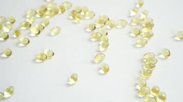 Hand arranging omega3 capsules on white surface in sequence. video