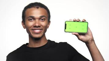Man pointing at smartphone with green screen for mockup video