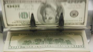 Close-up of money counting machine processing hundred-dollar bills video