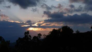 Time-lapse of the last minutes of the sunset, with clouds passing by and alder trees agitated by the wind, over the eastern Andean mountains of central Colombia. video