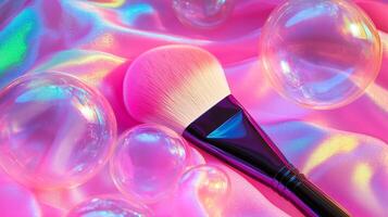 A makeup brush with large bubbles around it, against neon pink fabric. 1 photo