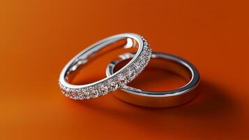 A wedding band, silver ring with diamond on an orange background. 10 photo