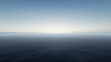 Calm Ocean View at Dusk with Gentle Waves and Distant Mountains photo