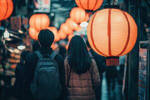 A couple strolls through a lively night market, illuminated by numerous glowing lanterns. The atmosphere is warm and inviting, creating a romantic backdrop for exploration. photo