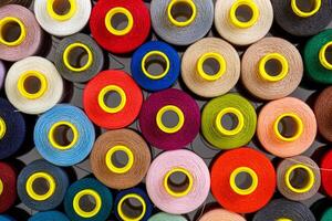close up set of multi-colored spools of thread for sewing photo