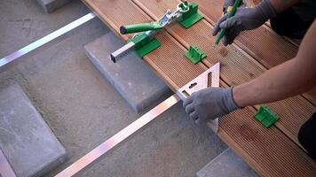 Construction of wooden deck stairs with precise measurements and tools at a home improvement site video