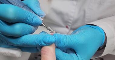 manicurist filing client nails removing nail plate with a milling machine video