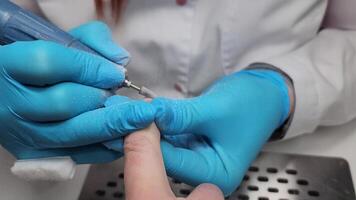 manicurist filing client's nails removing nail plate with milling machine video