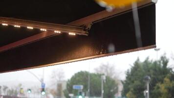 Raindrops falling on awning during a rainy afternoon in the city video
