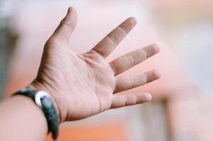 Open palm with a wristwatch reaching towards a soft abstract background photo