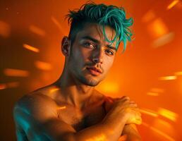 Portrait of young handsome man with green hair on orange background. Male Model Portrait with Teal Hair photo