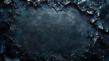 Moody, dark, textured abstract composition of rugged black rocks surrounding a smooth, deep blue center. Dark and atmospheric. photo
