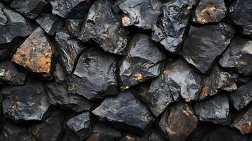 Textured wall of dark rocks and stones. Natural background featuring rough surfaces and various shapes in black and brown shades. photo