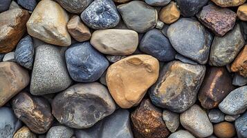 Textured background with colorful stones. The stones are smooth and varying in size and hues of brown, gray, and blue. photo