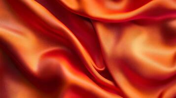 Abstract view of draped fabric showing a gradient of colors from red to orange and reflecting light forming curves and folds. photo