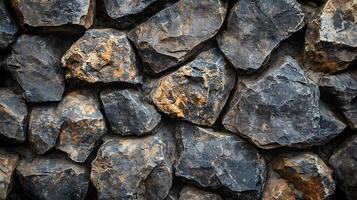 Sturdy wall constructed from rugged natural stone. Dark and rough texture evokes strength and resilience. Timeless architectural design. photo