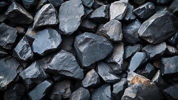 Dark, angular rocks form a textured, abstract surface, conveying ruggedness and natural strength. A close-up for builders, landscapers. photo