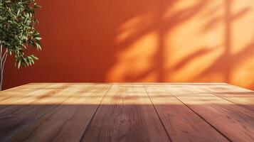 A minimalist indoor setting featuring a wooden table against a vibrant orange wall with plant shadows, creating a warm and inviting atmosphere. photo