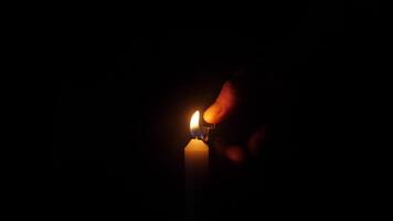 A gentle hand is lighting a beautiful candle, illuminating the surrounding darkness with a warm, inviting glow video