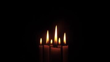 Five softly glowing candles gently illuminate the surrounding darkness, creating a calm and peaceful atmosphere video