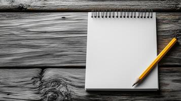 A blank spiral-bound notepad with a yellow pencil photo