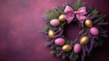 A wreath with gold eggs and purple flowers on a pink background photo