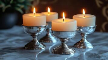 Four candles are lit in silver goblets photo