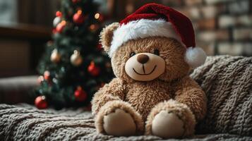 A teddy bear wearing a santa hat sits on a couch photo
