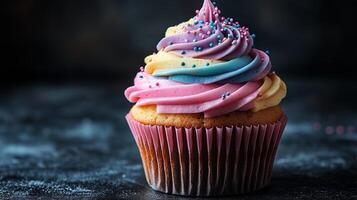 A cupcake with rainbow frosting on top photo